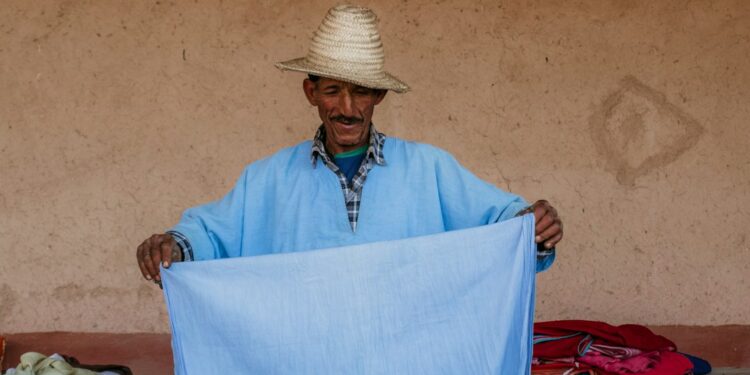 A Moroccan artisan weaving fabric inside a cooperative, showing the process behind building a capsule wardrobe