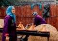 A Moroccan woman carefully preparing a traditional tagine, representing the depth of Moroccan food culture passed down.