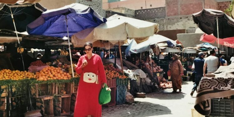 Una mujer marroquí selecciona higos frescos en un puesto del zoco, adoptando la cocina de otoño con productos de mercado de temporada