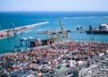 A freight logistics worker inspects containers at Tanger Med port, where post-summer freight demand peaks each autumn