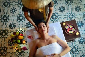 Une femme recevant un soin de hammam traditionnel avec du savon noir et un gant kessa dans un bain maure