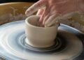 Beginner practicing a pottery hobby on a wheel in a Moroccan studio